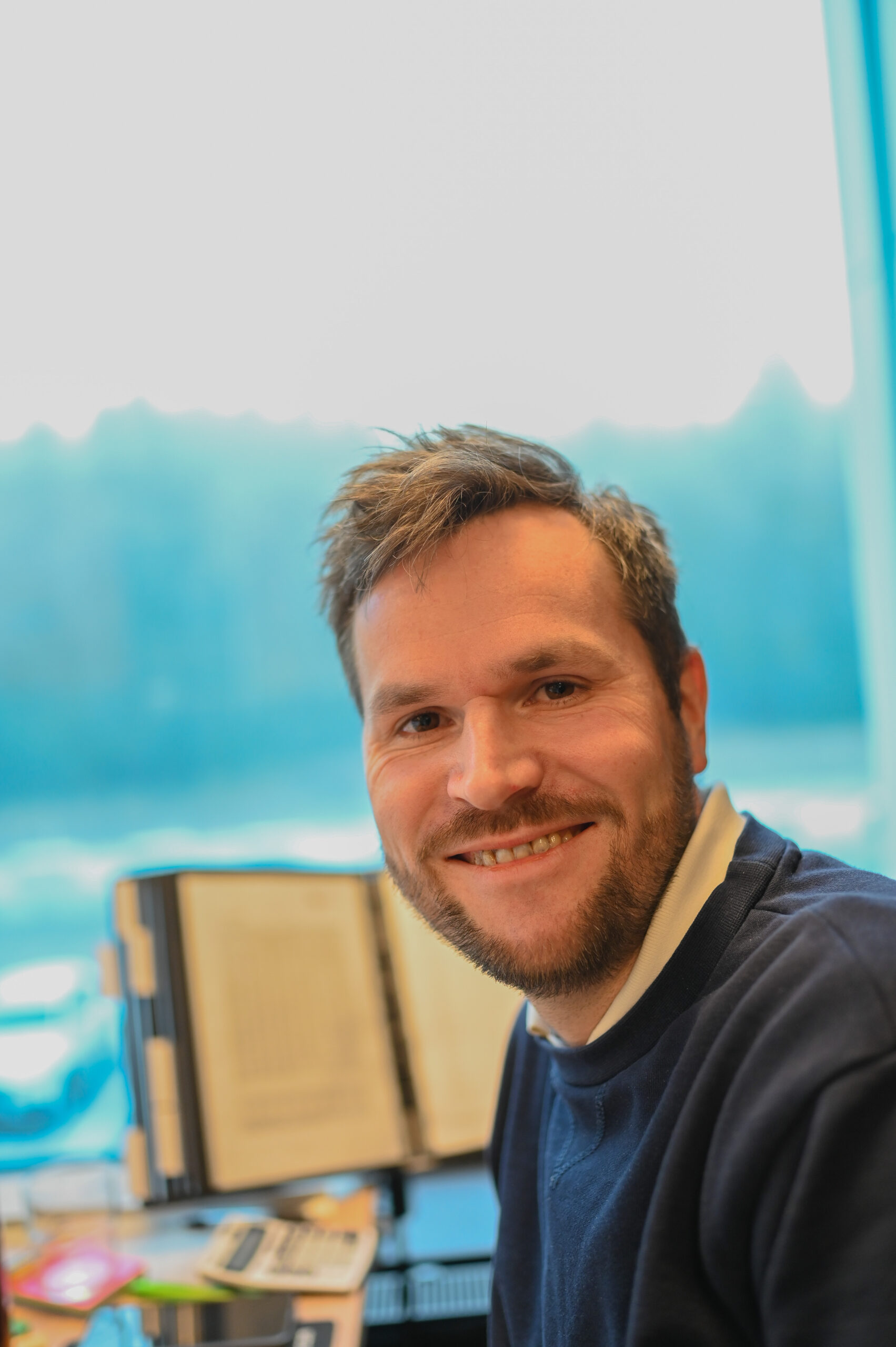 HP-O&F-24-03 Jørgen smiler på kontorplassen sin