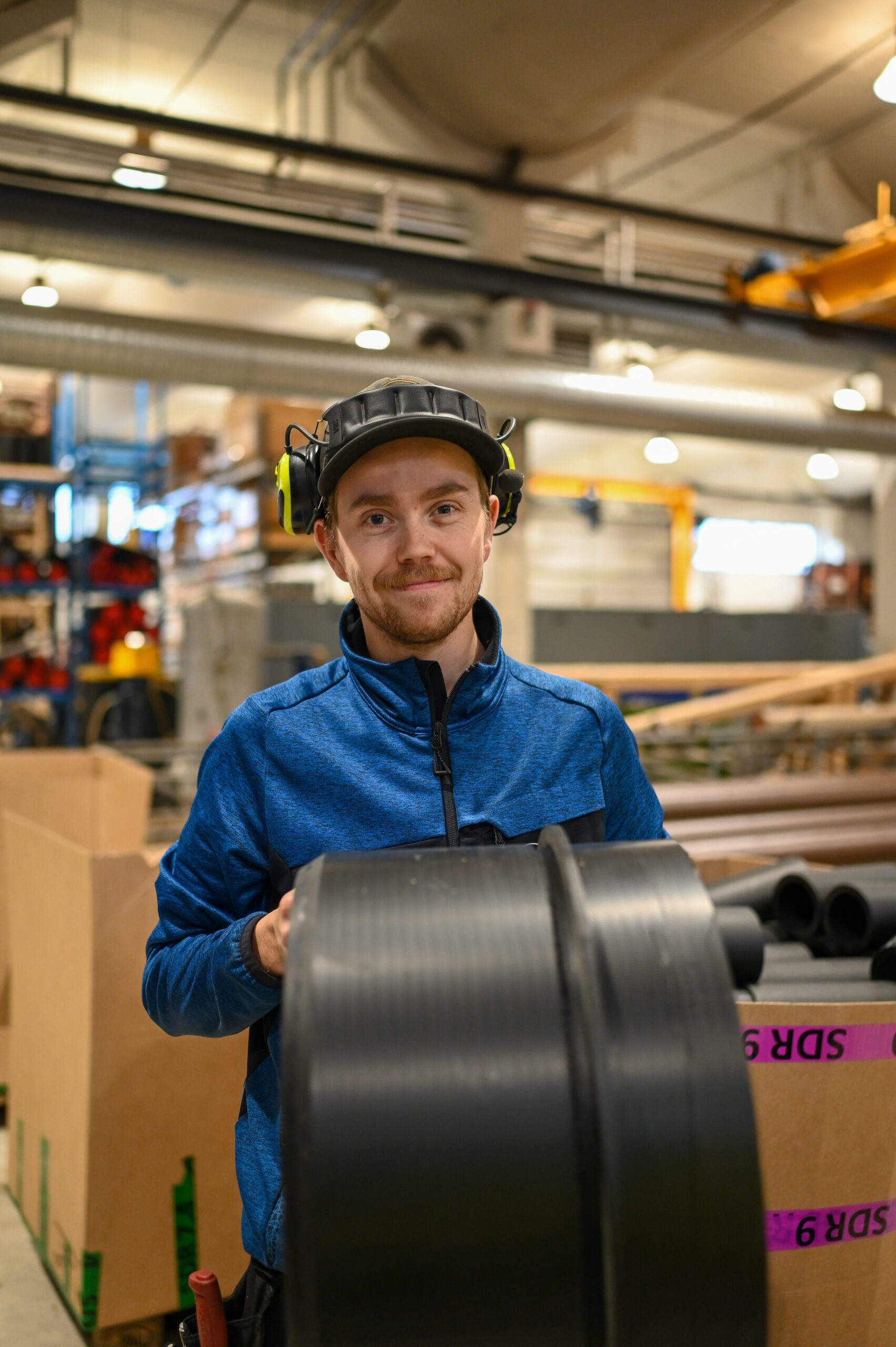 HP-O&F-24-12 Roger holder et rør i fabrikken til Hallingplast.